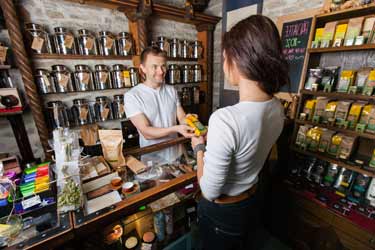 photo d'une boutique de thé en vrac dans laquelle une cliente achète des produits.