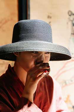 photo d'une jeune femme d'origine asiatique dégustant un bol de thé.